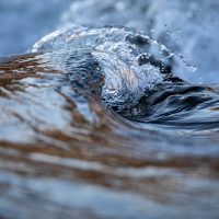 Water concept - river water flowing with light reflecting of its surface